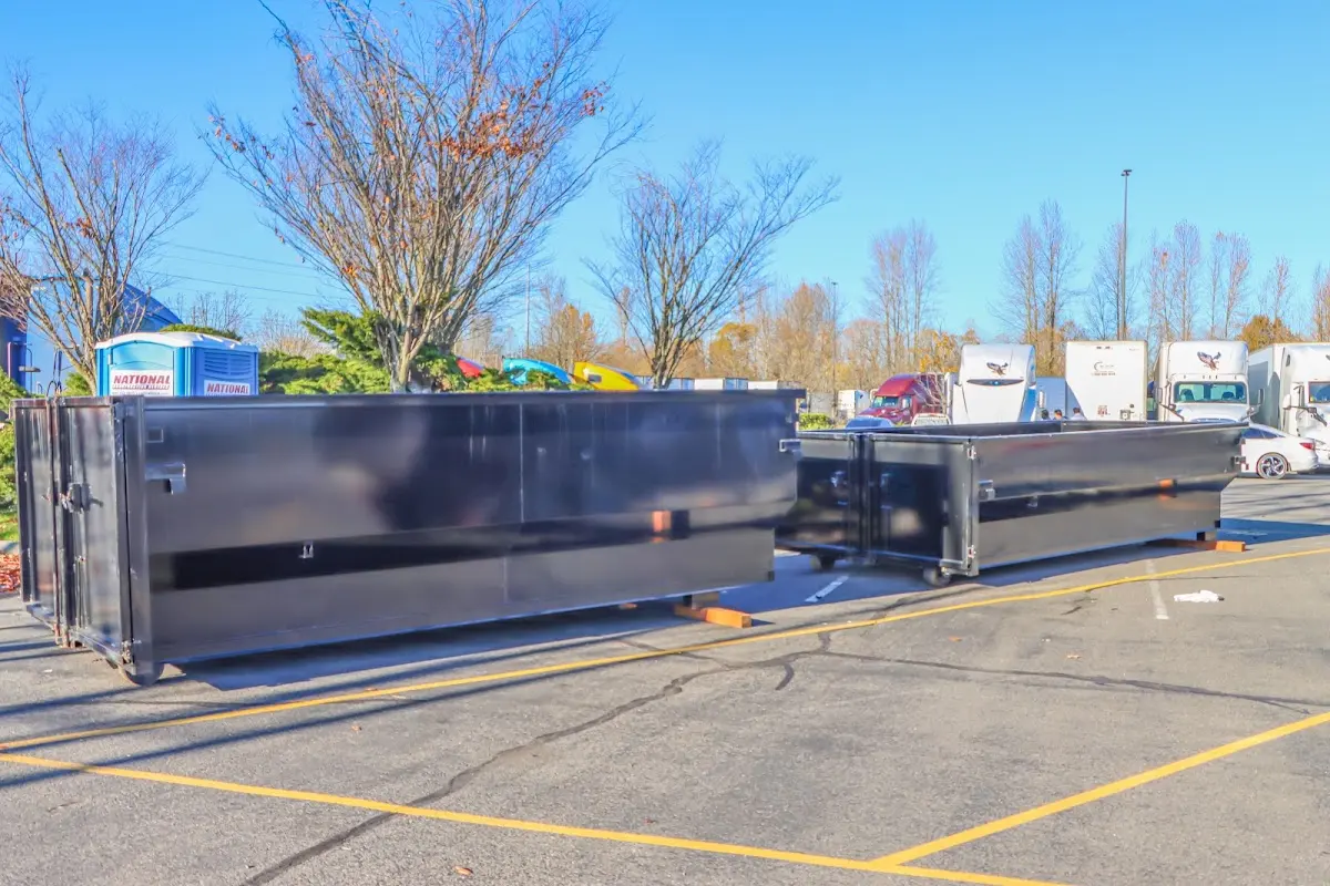 Professional dumpster rental service with roll-off container on residential driveway in EspaÃ±ola